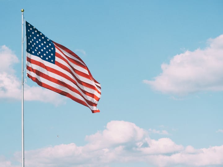 flag of U.S.A. under white clouds during daytime